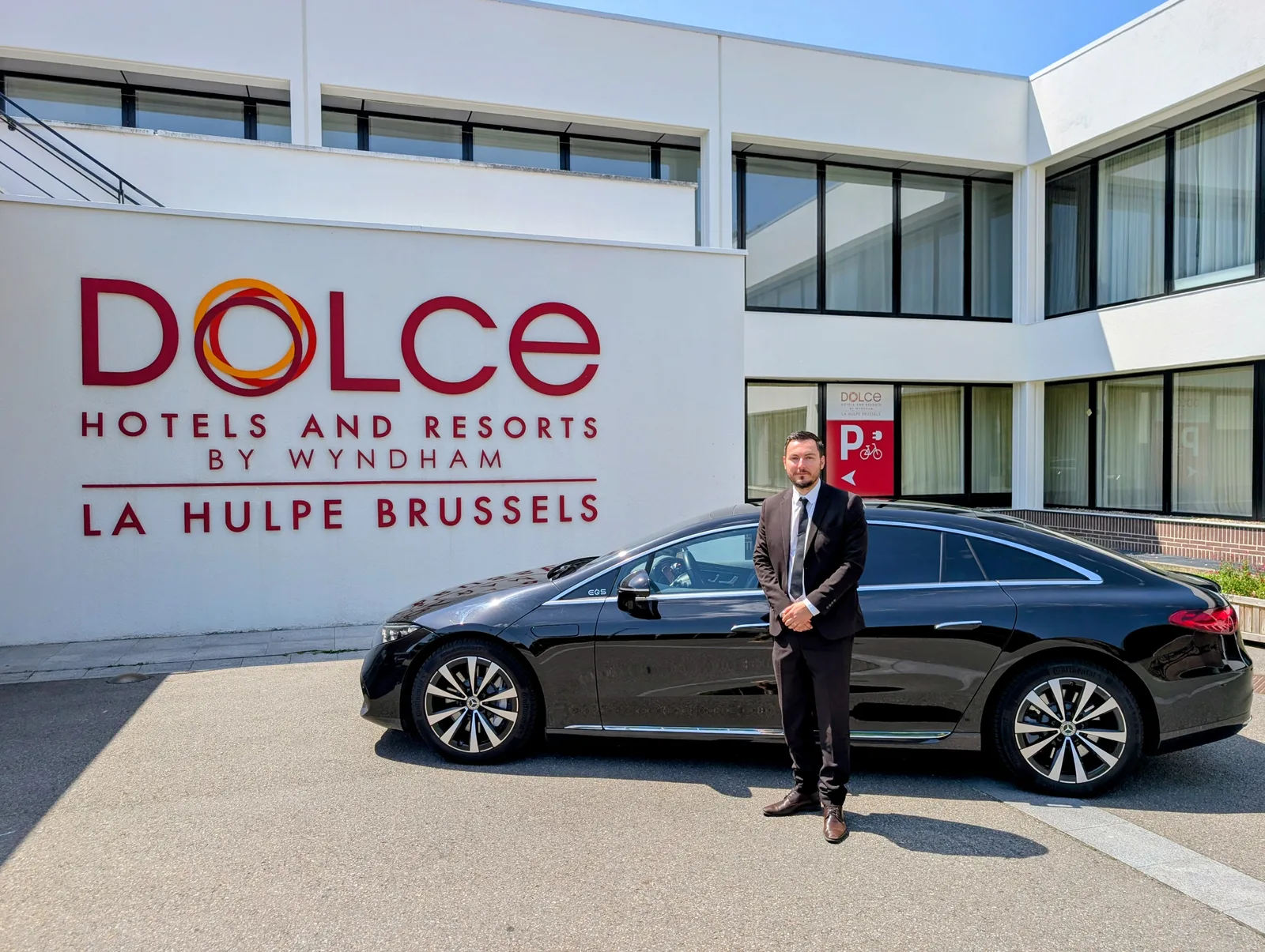 Chauffeur en costume devant limousine au Dolce la hulpe