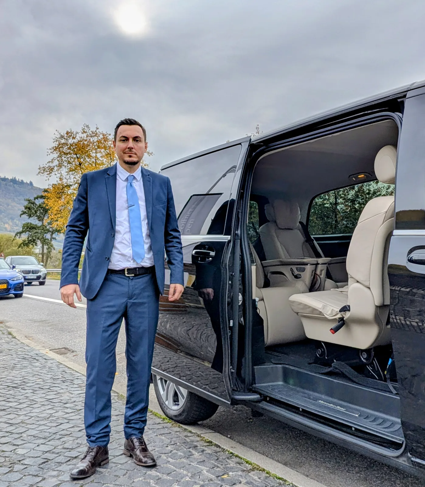 Chauffeur en costume avec minibus luxury